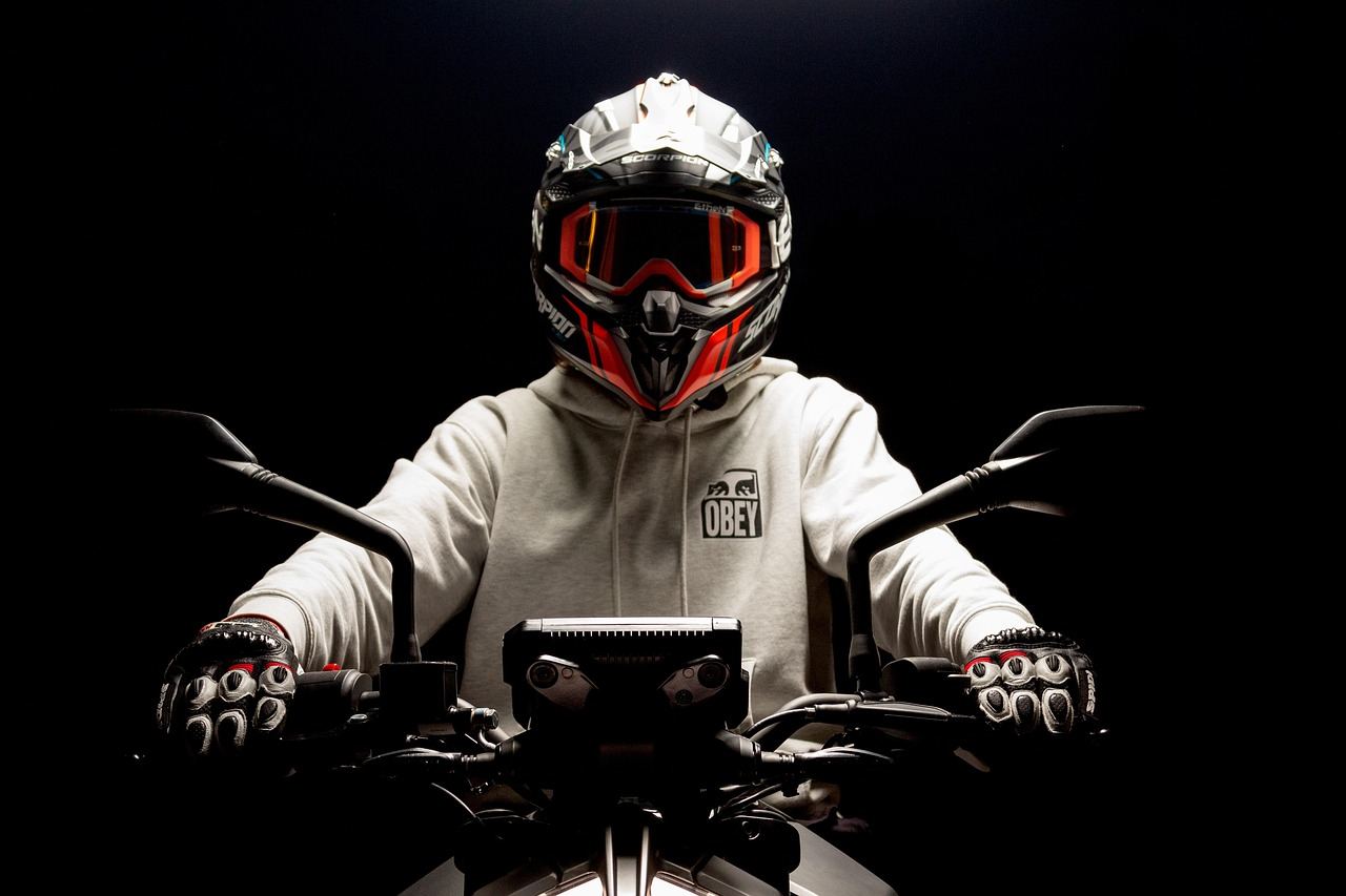 Motocyklista w kasku z otwartą szybą i kurtce motocyklowej