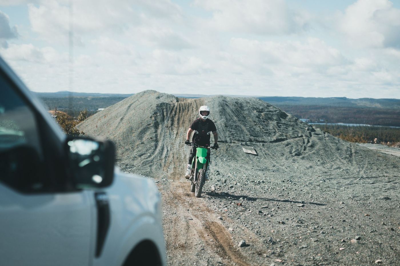 Motocyklista enduro jedzie po kamienistym, szutrowym terenie